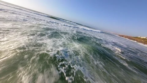 Dynamic coastal scene: waves surge with force toward land Видео 346370182