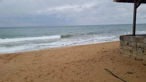 Dynamic coastal waves hitting sandy beach under cloudy sky scenery Stock Footage 322040789