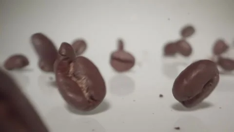 Dynamic coffee beans falling down a white background in extreme slow motion Stock-Footage 144781964