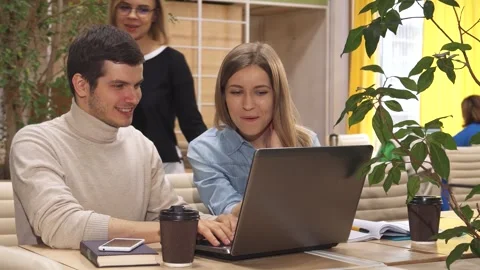 Dynamic collaboration among young professionals at a vibrant coworking hub Stock Footage 311985031
