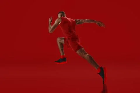Dynamic composition. Sprinter in red accelerating into motion, power and agility Stock Photos