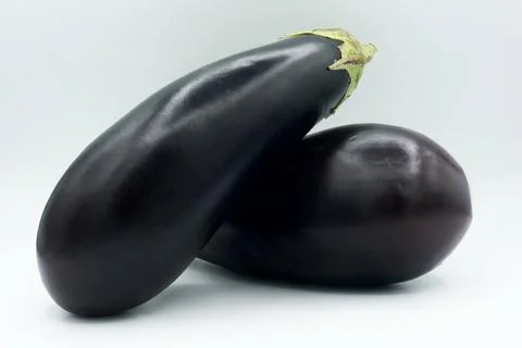Dynamic composition of two eggplants crossed over each other Stock Photos