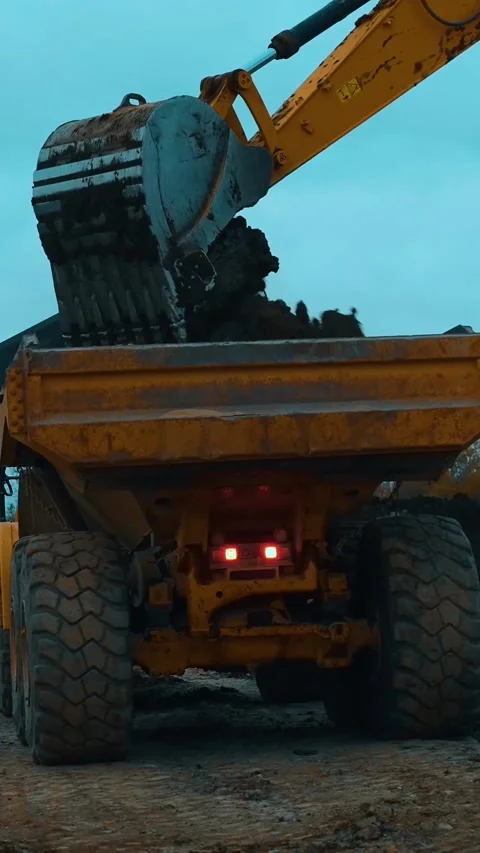 A dynamic construction scene highlighting a loader actively dumping material Stock Footage 312451849