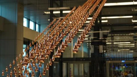 Dynamic Copper Teardrop Art Installation in Modern Interior Stock Photos