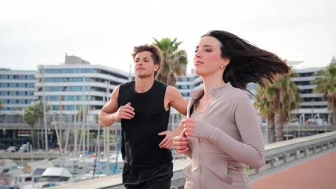 Dynamic couple engaged in energetic running together during an invigorating Stock Footage 313566917