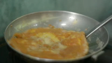 Dynamic Culinary Action Flipping a Golden Egg Omelet in a Frying Pan Stock Footage 344880470