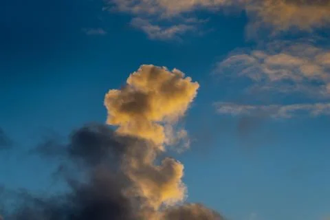 Dynamic cumulus cloud rising vertically in colorful evening Stock Photos