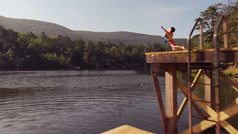 Dynamic Drone Capture of Boy Diving in Lake 스톡 동영상 109062071
