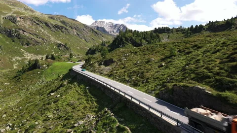 Dynamic drone dive and fly over road following sport car in Switzerland. 動画素材 143461347
