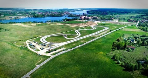 Dynamic drone establishing shot of racing track with cars riding Stock Footage 89416198