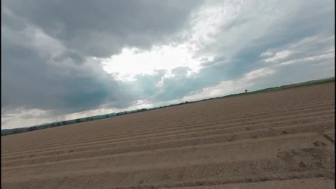 Dynamic Drone Flyover of Plowed Agricultural Field Stock Footage 276871364