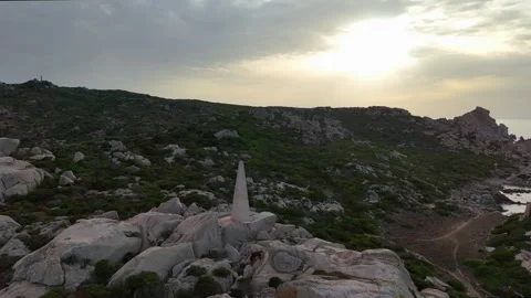 Dynamic Drone Orbit Lighthouse with Waves and Rocks Sardegna Sunset Vídeo Stock 333516299