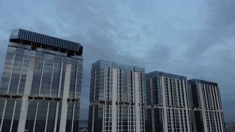 Dynamic Drone Perspective of Sleek Glass Towers Reaching Skyward Under a Dr.. Stock Footage 325204081