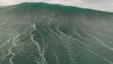 Dynamic drone shot of breaking barrel wave on turquoise ocean during cloudy day Stock Footage 163288455