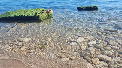 Dynamic drone view of clear shallow water with mossy rocks Stock Footage 322161125