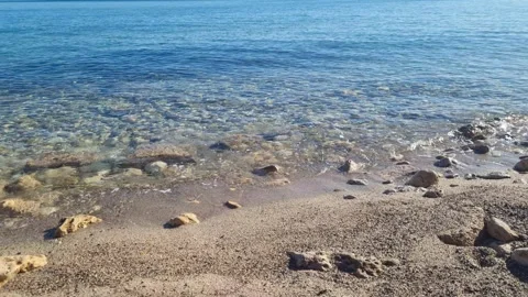 Dynamic drone view of clear shoreline water with scattered stones Stock Footage 322161123