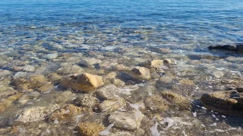 Dynamic drone view of shallow clear water over rocky shoreline Stock Footage 322161127