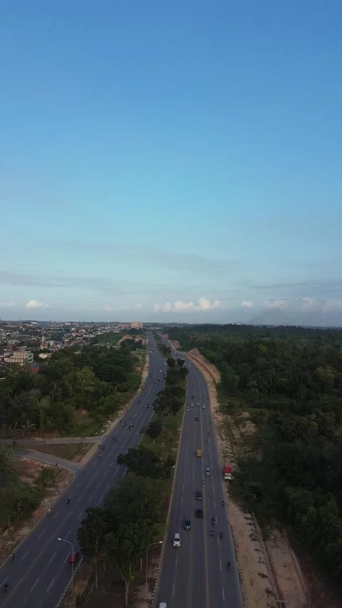 Dynamic drone view of a vibrant multi-lane highway flowing through a verdan.. Stock Footage 339037563