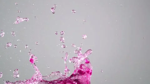 Dynamic explosion of magenta liquid droplets in high speed close up view Stock Footage 327597925