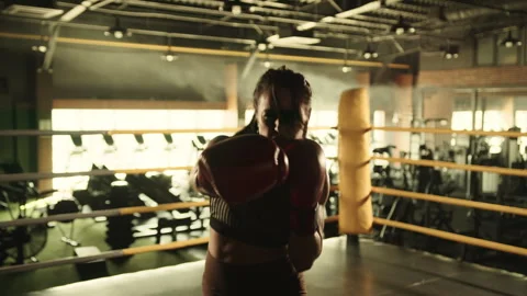 Dynamic Female Boxer Training with Direct Punches Towards Camera in Gym Stock Footage 269202872