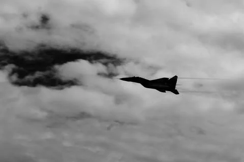 Dynamic fighter jet captured mid-flight against turbulent clouds Stock Photos