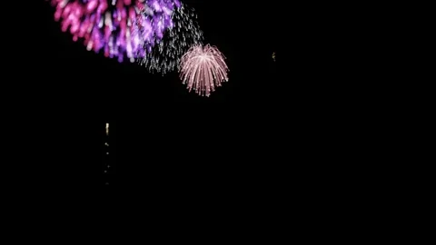 A dynamic fireworks display against a dark night sky Stock Footage 340141091