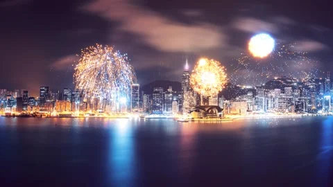 A dynamic fireworks display over Hong Kong's skyline at night, captured from Stock Footage 344105767