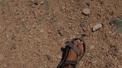 Dynamic first person walking through a sun scorched rocky desert trail in Vídeos de archivo 346247221