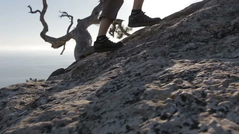 Dynamic following close-up shot of a man climbing a mountain. Detail of Stock Footage 103829691