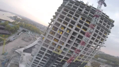 Dynamic footage of an FPV drone flying around the building and a crane near it Stock Footage 139608948