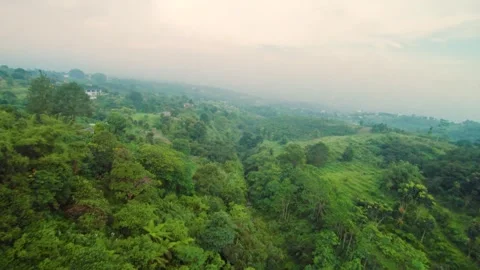 Dynamic FPV drone descent above green hills and homes Stock Footage 326589449