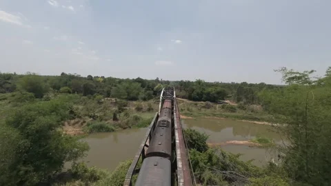 Dynamic FPV drone flight diving towards vintage passenger train crossing an old Stock Footage 335923459