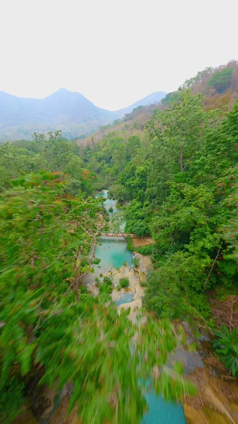 Dynamic FPV drone flight over tropical Kuang Si Waterfall in Laos Stock Footage 253055110