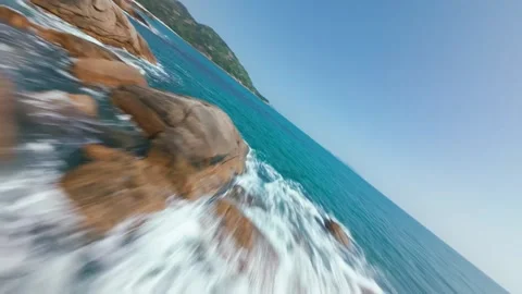 Dynamic FPV Drone Flight Over Rocky Ocean Coastline and Lush Green Cliff Stock Footage 319368131
