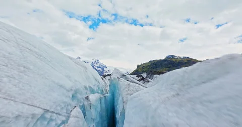 Dynamic FPV drone flight skimming above and between deep glacier crevasses. Видео 339018680