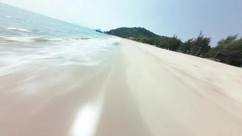 Dynamic FPV Drone Skimming Low and Fast Over Long White Sand Beach Stock Footage 319368133