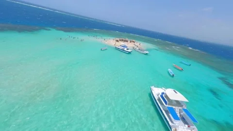 Dynamic Fpv flight over crowded sandy island with parking boats surrounded 스톡 동영상 195709601