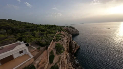 Dynamic fpv shot flying along the sunset cliffs and blue sea Stock Footage 201223739