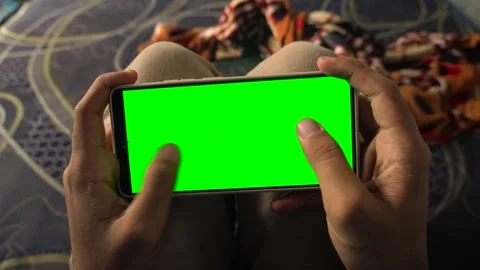 Dynamic green screen transition effect on a smartphone held horizontally by.. Stock Footage 340490768