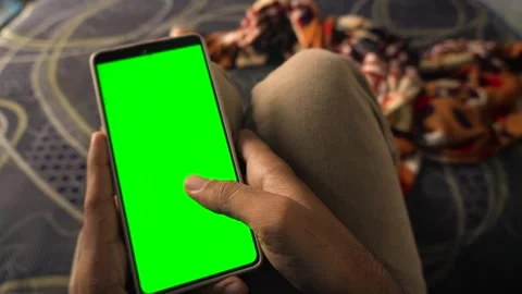 Dynamic green screen transition effect on a smartphone held vertically by a.. Stock Footage 340490769