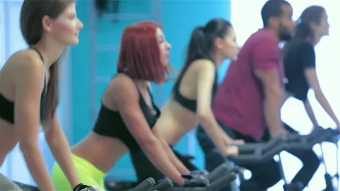 Dynamic group of five friends pedaling intensely on stationary bicycles Stock Footage 311822400