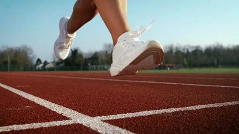 Dynamic, high-speed, Close-up of a runner's legs and white sneakers on a track. Stock Footage 344895699