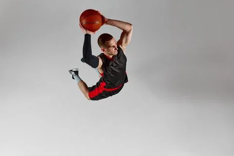 Dynamic image of concentrated young man, basketball player throwing all in a Stock Photos