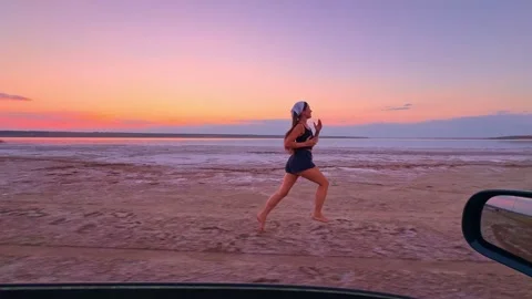 Dynamic Jogging Action on Salt Lake Beach at Sunset Stock Footage 344818572