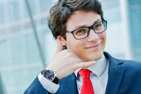 Dynamic junior executive gesturing to call Stock Photos