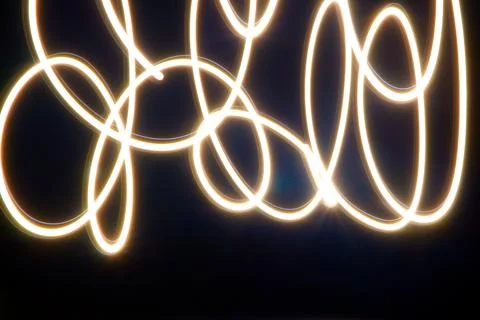 Dynamic light trails dancing across a dark canvas Stock Photos