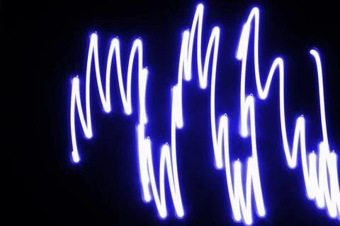 Dynamic light trails dancing across a dark canvas Foto stock