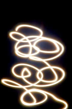 Dynamic light trails dancing across a dark canvas Foto stock