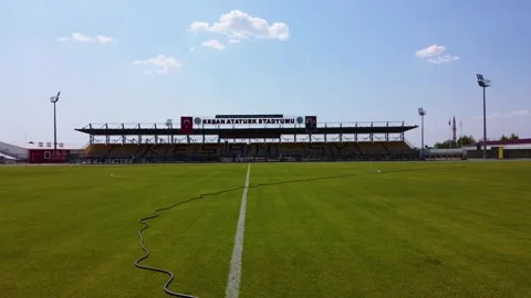 Dynamic low-altitude aerial drone flight sweeping across a vibrant green footbal Stock Footage 320848141