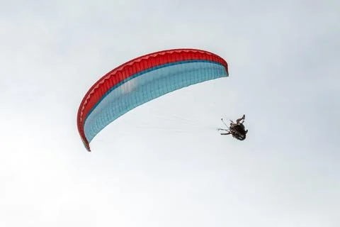 Dynamic low angle shot of paragliders performing a turn with a vibrant canopy Foto stock